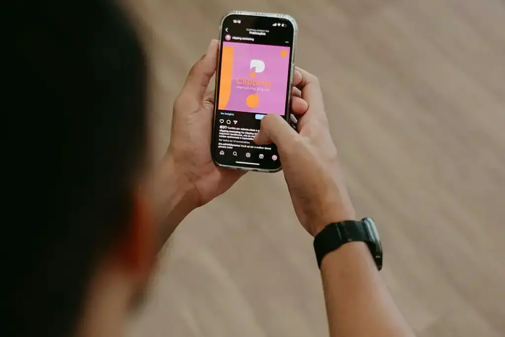 Man scrolling social media on a phone while wearing a watch