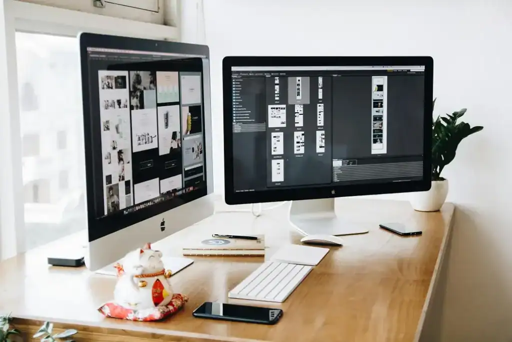 Two desktop screens and a keyboard on an office desk