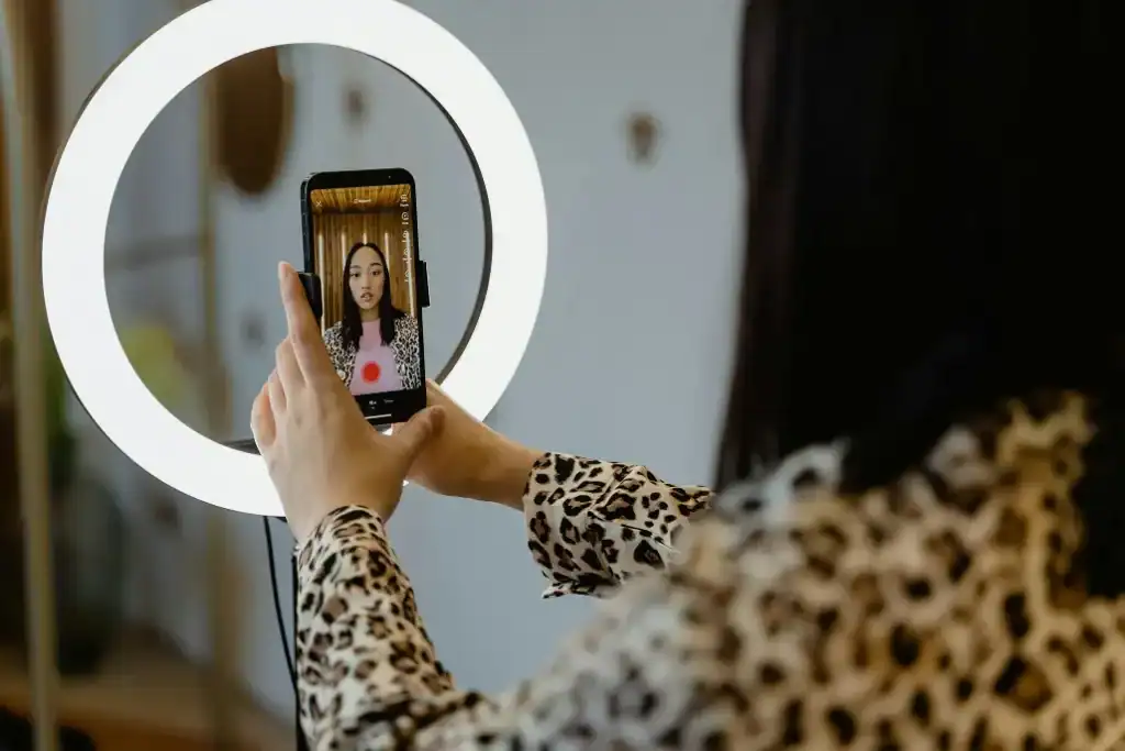 Lady taking a selfie ifront of a selfie light